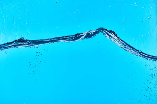 Água clara ondulada no fundo azul com gotas — Fotografia de Stock