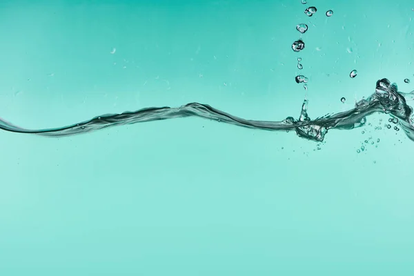 Eau transparente ondulée sur fond turquoise avec éclaboussures — Photo de stock