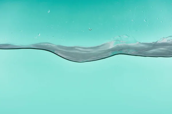 Wavy transparent water on turquoise background with leaking drops — Stock Photo