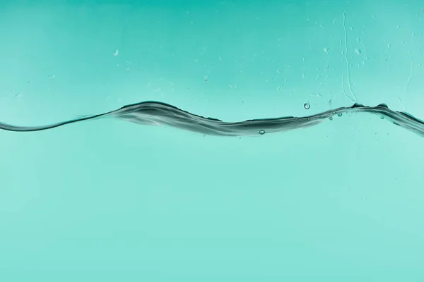 Wavy transparent water on turquoise background with flowing drops — Stock Photo