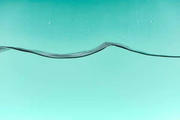 Wavy clear water on turquoise background with drops — Stock Photo