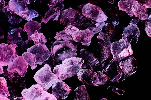 Top view of ice cubes with purple lighting isolated on black — Stock Photo