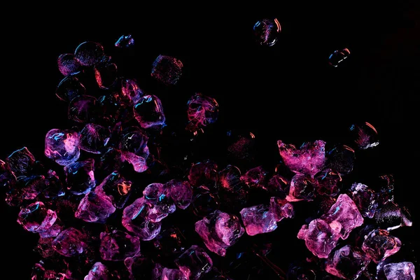 Vue de dessus des glaçons gelés avec éclairage violet isolé sur noir — Photo de stock