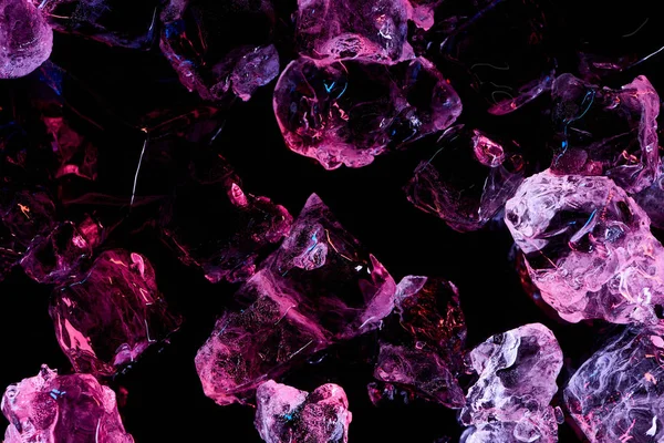 Top view of frosted ice cubes with purple lighting isolated on black — Stock Photo