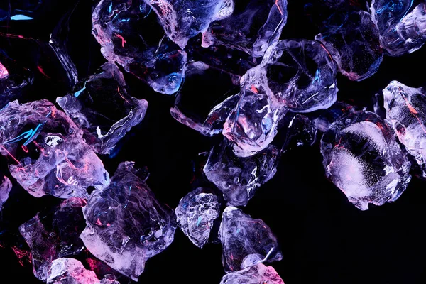 Vista superior de cubos de gelo transparentes com iluminação roxa isolada em preto — Fotografia de Stock