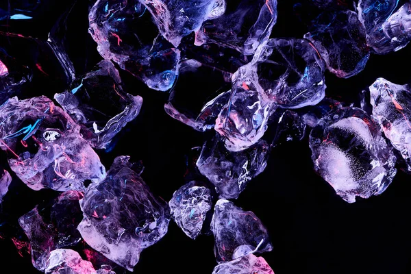 Top view of transparent ice cubes with purple illumination isolated on black — Stock Photo