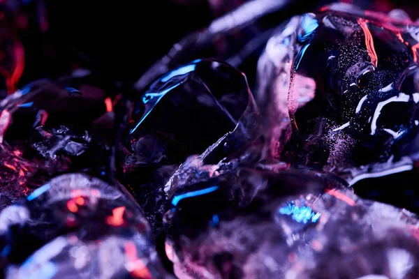 Vista de cerca de cubitos de hielo con iluminación púrpura aislada en negro - foto de stock