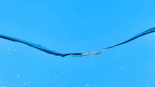 Transparentes Wasser auf blauem Hintergrund mit Tröpfchen — Stockfoto
