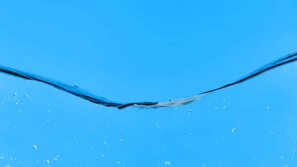 Eau transparente sur fond bleu avec des gouttelettes — Photo de stock