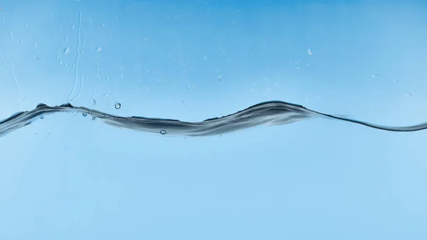 Eau transparente ondulée sur fond bleu avec des gouttelettes — Photo de stock