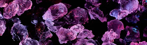 Panoramic shot of transparent ice cubes with purple illumination isolated on black — Stock Photo