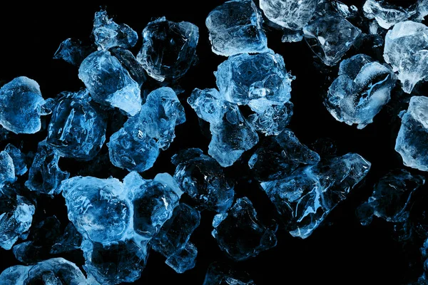 Vista superior de cubitos de hielo congelados con iluminación azul aislada en negro - foto de stock