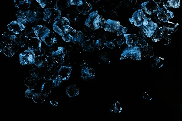 Vista superior de cubitos de hielo congelados con luz azul aislada en negro - foto de stock