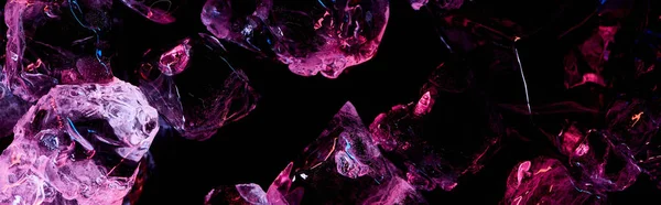 Plano panorámico de cubos de hielo transparentes con luz púrpura aislada en negro - foto de stock