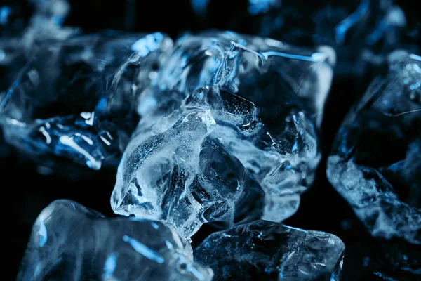 Nahaufnahme gefrorener Eiswürfel mit blauer Beleuchtung isoliert auf schwarz — Stockfoto