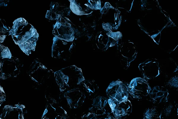 Vue de dessus des glaçons clairs gelés avec éclairage bleu isolé sur noir — Photo de stock