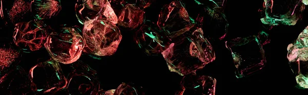 Панорамний знімок прозорих кубиків льоду з червоним і зеленим освітленням ізольовано на чорному — стокове фото