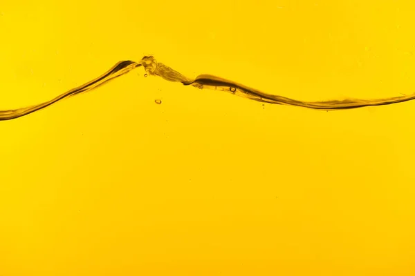 Welliges transparentes tiefes Wasser mit Blasen auf gelbem Hintergrund — Stockfoto