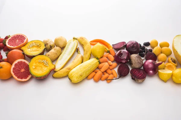 Vista superior de cebollas rojas, remolachas, zanahorias, patatas, albaricoques, melón, plátanos, calabaza de calabacín y pomelo sobre fondo blanco - foto de stock