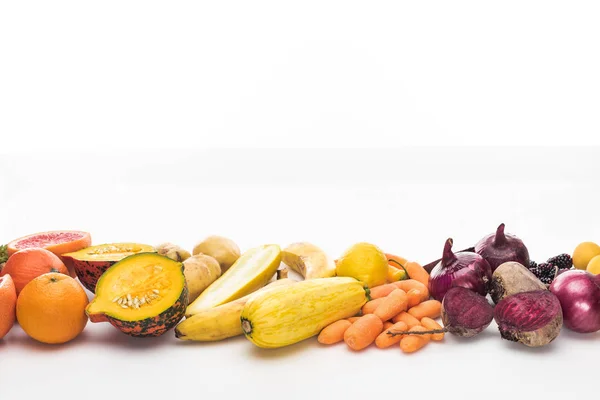 Zanahorias, cebollas rojas, remolachas, calabacines, naranjas y calabazas sobre fondo blanco - foto de stock