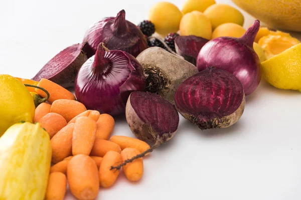 Zanahorias, cebollas rojas, remolachas, albaricoques sobre fondo blanco - foto de stock