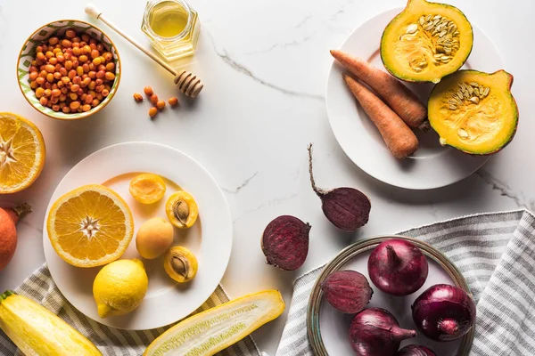 Vista dall'alto di piatti con verdure di autunno di stagione e frutta su superficie di marmo — Foto stock