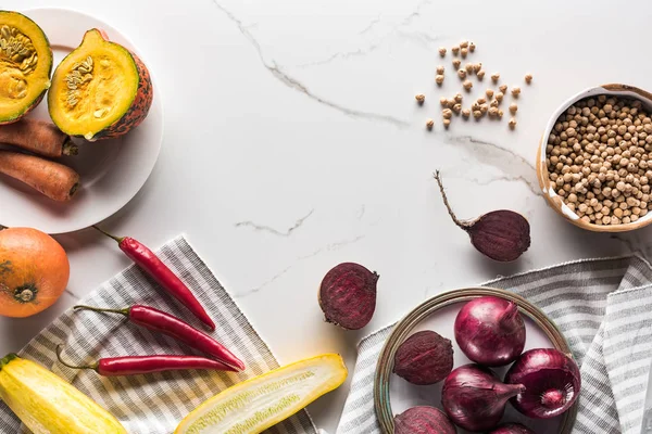 Blick auf Teller mit Gemüse der Saison und Kichererbsen auf Marmoroberfläche — Stockfoto