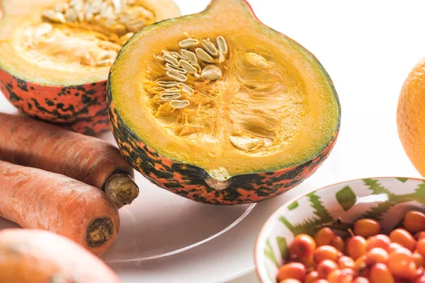 Mitades de calabaza y zanahorias en el plato en la superficie de mármol - foto de stock