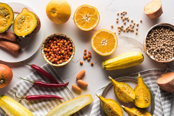 Top view of orange autumn fruits and vegetables on marble surface with berries and chickpea — Stock Photo