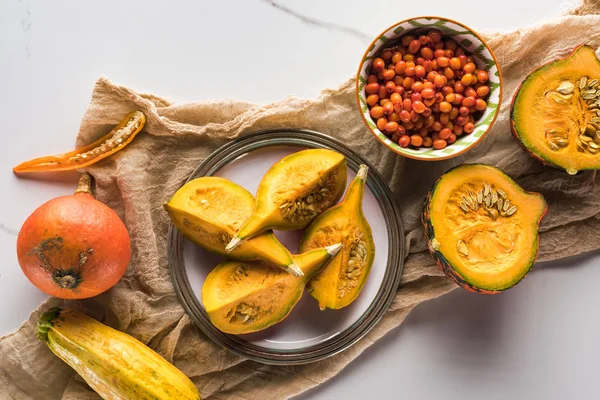 Top view of plate with pumpkin on canvas near bowl with berries — Stock Photo