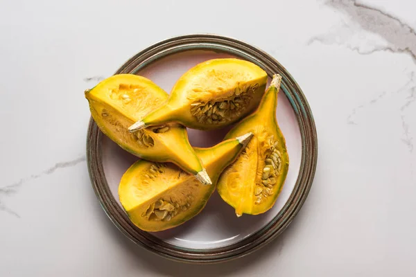 Top view of plate with pumpkin parts on marble surface — Stock Photo