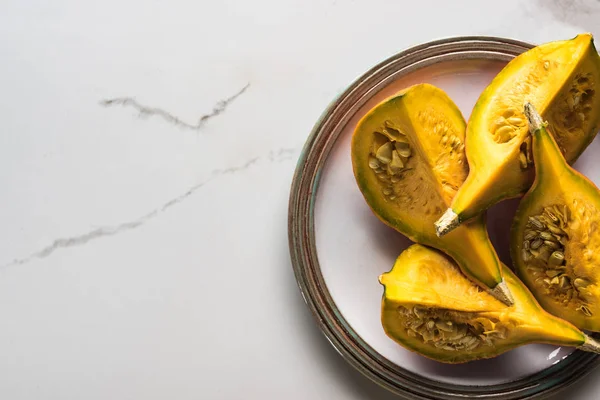 Top view of plate with pumpkin parts on marble table — Stock Photo