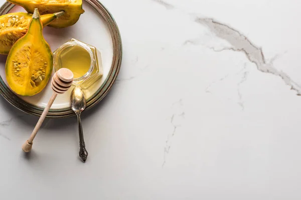 Vue de dessus de la plaque avec citrouille et miel et cuillère sur la surface du marbre — Photo de stock