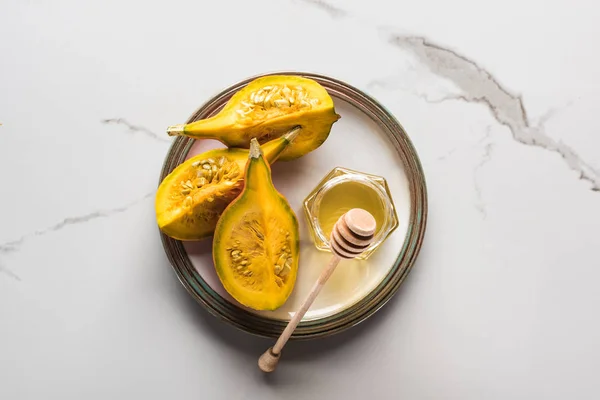 Top view of plate with pumpkin and honey on marble surface — Stock Photo