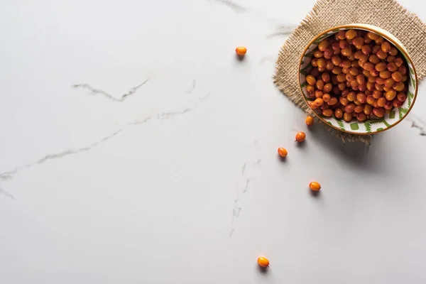 Top view of bowl with berries on marble surface with hessian — Stock Photo