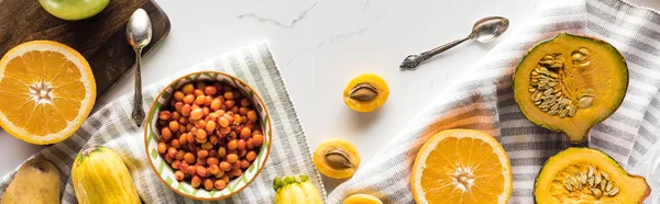 Plano panorámico de calabaza, bayas, albaricoques con cucharas en la superficie de mármol - foto de stock