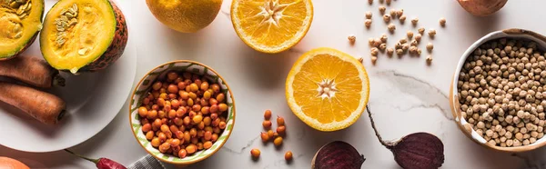 Panoramic shot of bowls with chickpea and berries near raw fruit and vegetables on marble surface — Stock Photo