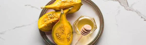 Panoramic shot of ripe fresh pumpkin and honey on marble table — Stock Photo