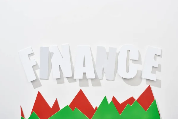 Top view of finance inscription with green and red statistic graphs on white background — Stock Photo
