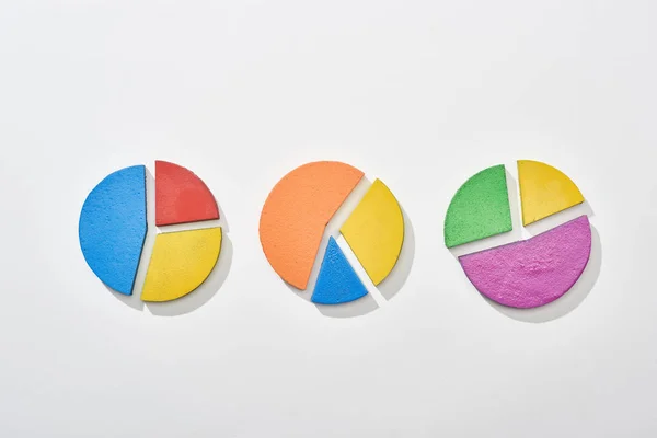 Top view of multicolor pie charts on white background — Stock Photo