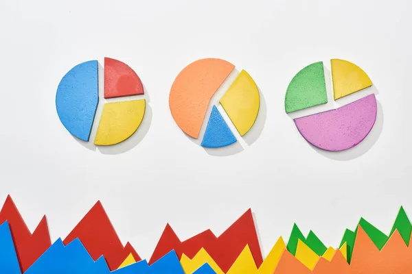 Top view of multicolor statistic graphs and pie charts on white background — Stock Photo