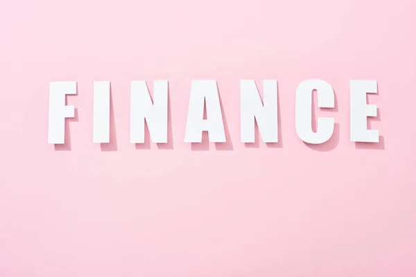 Top view of white finance inscription on pink background — Stock Photo