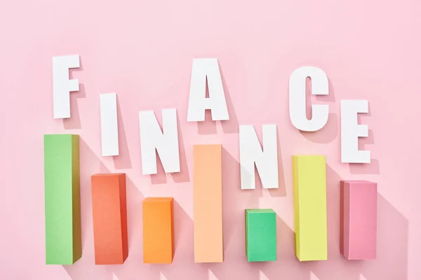 Верхний вид финансовой надписи с цветным графиком на розовом фоне — стоковое фото