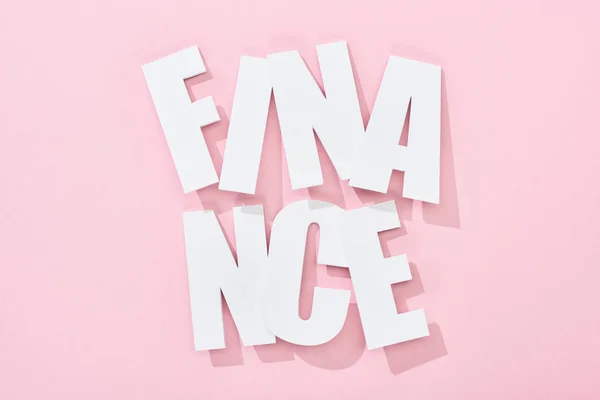 Top view of white finance inscription with shadow on pink background — Stock Photo