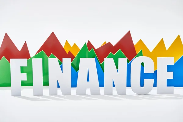 Grafici statistici multicolore dietro iscrizione finanza su sfondo bianco — Foto stock