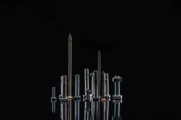 Vários parafusos metálicos isolados em preto com espaço de cópia — Fotografia de Stock