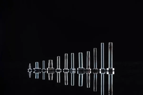 Novos parafusos metálicos brilhantes isolados em preto — Fotografia de Stock
