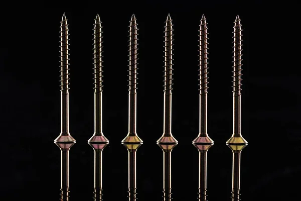 Row of new shiny metallic screws isolated on black — Stock Photo