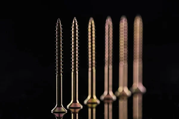 Row of spotless metallic screws isolated on black — Stock Photo