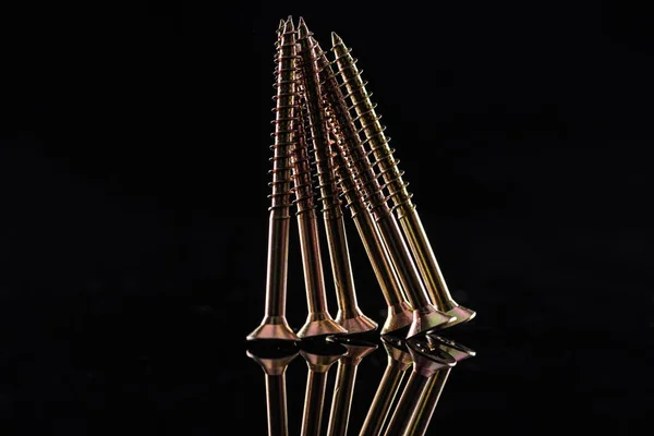 Neue metallisch glänzende Schrauben isoliert auf schwarz — Stockfoto